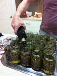 Once the olives are put in jars with fresh brine (and a few tasty additions...like fresh ginger!) we top them with olive oil.